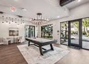 Thumbnail 49 of 57 - A room with a pool table and a chandelier at The Stadler Luxury Apartments, Bradenton, Florida