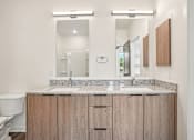 Thumbnail 30 of 39 - A bathroom with a sink, mirror, and wooden cabinets.
