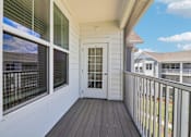 Thumbnail 80 of 124 - Private balcony with dark wood decking and metal railing at Velara Luxury Apartments, Ponte Vedra Beach, Florida