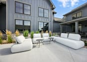 Thumbnail 39 of 59 - A white couch and table are on a patio in front of a house at The Garrison Luxury Apartment Homes, Fountain, CO 80817