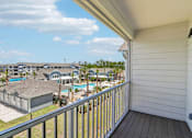 Thumbnail 74 of 124 - Covered balcony with view of pool and palm trees at Velara Luxury Apartments, Florida