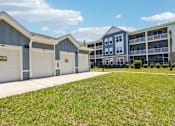 Thumbnail 78 of 124 - Garages with apartment buildings and green lawn at Velara Luxury Apartments, Florida, 32081