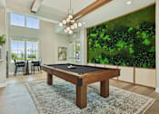 Thumbnail 23 of 62 - A pool table in a room with a green wall.