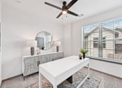 Thumbnail 29 of 43 - A white room with a table, a mirror, and a ceiling fan at The Hadley - North Port, FL Apartments, North Port, Florida