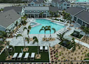 Thumbnail 16 of 62 - A pool surrounded by palm trees and lounge chairs.