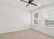 Thumbnail 85 of 124 - Empty bedroom with two windows and ceiling fan at Velara Luxury Apartments, Florida