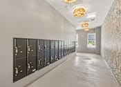 Thumbnail 83 of 124 - Mailroom with builtin lockers and decorative lighting at Velara Luxury Apartments, Ponte Vedra Beach, FL 32081