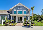 Thumbnail 94 of 124 - Leasing office entrance with covered walkway and landscaping at Velara Luxury Apartments, Florida