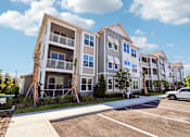 Thumbnail 2 of 124 - Modern apartment building exterior with parking and landscaping at Velara Luxury Apartments, Ponte Vedra Beach, FL