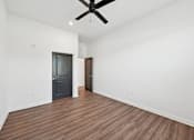 Thumbnail 53 of 60 - A room with a ceiling fan and wooden flooring.