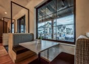 Thumbnail 27 of 45 - a dining room with a large window and a table at The BLVD at Wilson Crossings, Michigan, 49418