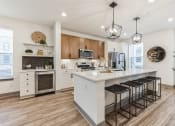 Thumbnail 36 of 58 - an open kitchen with a large island with bar stools at Meridian at CityPlace, Minnesota