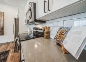 Thumbnail 33 of 45 - an updated kitchen with stainless steel appliances and white cabinets at The BLVD at Wilson Crossings, Michigan