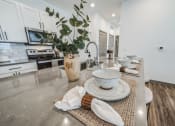 Thumbnail 23 of 45 - an open kitchen and dining area with white cabinets and stainless steel counter tops at The BLVD at Wilson Crossings, Wyoming Michigan
