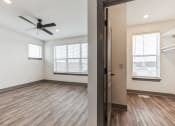 Thumbnail 32 of 58 - an empty living room with a ceiling fan and a window at Meridian at CityPlace, Minnesota, 55125