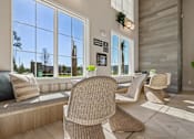 Thumbnail 103 of 124 - Resident lounge with floortoceiling windows and wicker seating at Velara Luxury Apartments, Florida