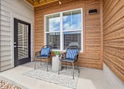Thumbnail 11 of 24 - Two chairs are placed on a patio with a table between them.