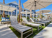 Thumbnail 111 of 124 - Resort style pool deck with lounge chairs and umbrellas at Velara Luxury Apartments, Ponte Vedra Beach