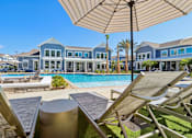 Thumbnail 18 of 124 - Pool deck with lounge chairs umbrellas and fire feature at Velara Luxury Apartments, Florida, 32081