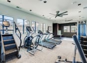 Thumbnail 37 of 68 - a gym with cardio equipment and windows in a building  at Grandstone at Sunrise, Peoria