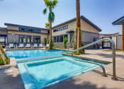 Thumbnail 31 of 68 - a swimming pool with a building in the background at Grandstone at Sunrise, Peoria