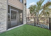 Thumbnail 30 of 60 - A patio with a black fence and a glass door.