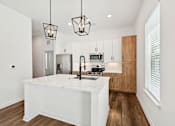Thumbnail 3 of 43 - A modern kitchen with a white island and wooden cabinets. at The Hadley - North Port, FL Apartments, Florida