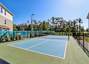 Thumbnail 24 of 124 - Tennis court with fencing and net at Velara Luxury Apartments, Florida