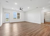 Thumbnail 22 of 24 - A room with wooden flooring and a ceiling fan.