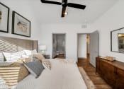 Thumbnail 13 of 45 - a bedroom with a large bed and a ceiling fan at The BLVD at Wilson Crossings, Wyoming, Michigan