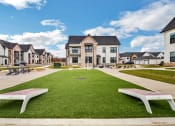 Thumbnail 10 of 45 - a green lawn with benches in front of houses at The BLVD at Wilson Crossings, Wyoming, 49418