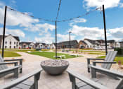 Thumbnail 18 of 45 - a park with benches and fire pits with houses in the background at The BLVD at Wilson Crossings, Wyoming, 49418