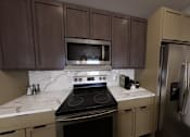 Thumbnail 12 of 16 - A kitchen with a stove, microwave, and refrigerator.at Terrassa Luxury Apartments, Saint Augustine