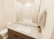 Thumbnail 6 of 18 - A white toilet sits next to a sink in a bathroom.