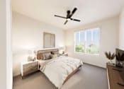 Thumbnail 21 of 48 - A bedroom with a large bed and a ceiling fan.