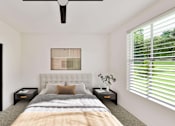 Thumbnail 15 of 32 - A bedroom with a bed, nightstands, and a ceiling fan.