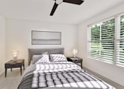 Thumbnail 23 of 32 - A bedroom with a large bed and a ceiling fan.