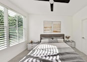 Thumbnail 21 of 32 - A bedroom with a bed, nightstands, and a ceiling fan.