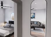 Thumbnail 21 of 21 - A bedroom with a bed, a ceiling fan, and a mirrored wall at Refinery at Pointe17 Apartments, Arizona