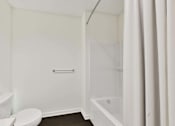 Thumbnail 20 of 32 - A white bathroom with a toilet, sink, and bathtub.