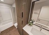Thumbnail 7 of 32 - A bathroom with a toilet, sink, and mirror.