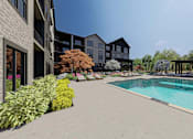 Thumbnail 30 of 32 - A pool area with a building in the background.