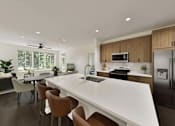 Thumbnail 18 of 32 - A modern kitchen with a white countertop and brown chairs.