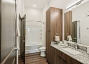 Thumbnail 29 of 57 - A bathroom with a toilet, sink, and mirror at The Stadler Luxury Apartments, Bradenton