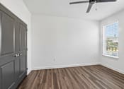 Thumbnail 35 of 124 - Empty bedroom with wood flooring and ceiling fan at Velara Luxury Apartments, Ponte Vedra Beach, 32081