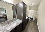 Thumbnail 41 of 56 - a bathroom with a sink and a mirror and a shower at Watermark at Steele Crossing, Fayetteville