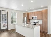 Thumbnail 27 of 39 - A modern kitchen with wooden cabinets and a granite countertop.