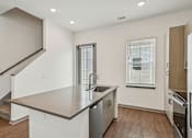 Thumbnail 61 of 68 - A modern kitchen with a stainless steel sink and wooden floors. at The Sophia, Venice, FL