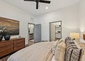 Thumbnail 37 of 60 - A bedroom with a bed, dresser, and ceiling fan.