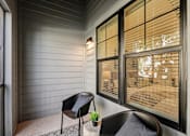 Thumbnail 15 of 57 - A chair sits on a porch with a potted plant on the table at The Stadler Luxury Apartments, Bradenton